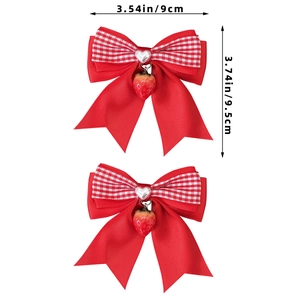 Détail du nœud papillon à carreaux rouges et blancs avec pendentif fraise et perle