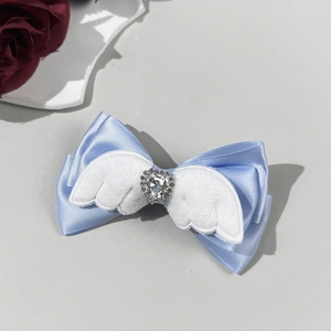 Detail van lichtblauwe strik haarclip met witte pluche engelenvleugels en hart van strass
