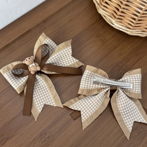 Détail de pinces à cheveux ourson montrant la texture du tissu et le clip crocodile