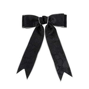 Barrette nœud noir élégante avec longs rubans et bordure argentée sur un fond blanc pur