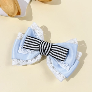 Detail of blue Lolita style hair clip with striped bow and delicate white lace borders
