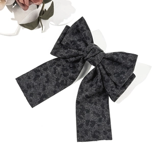 Vue détaillée de la barrette nœud en denim à motif léopard avec de longs rubans élégants