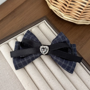 French vintage houndstooth bow hair clip with rhinestone heart on beige velvet display