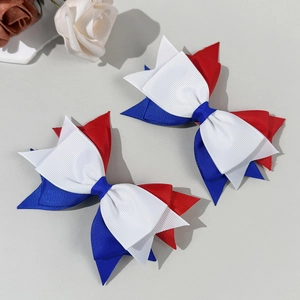 Detail of red, white and blue grosgrain ribbon bow hair clips with layered texture