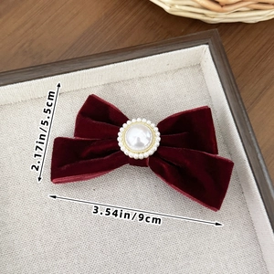 Detailed size view of burgundy velvet bow hair clip with vintage pearl center ornament