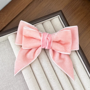Detail view showing textured pink velvet layers of the elegant double bow hair clip