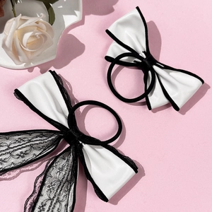Elegant white faux leather bow hair tie with black lace ribbon on pink background