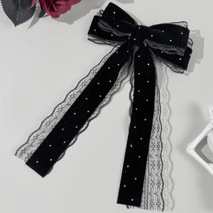 Détail d'une barrette en velours noir avec bordure en dentelle et perles blanches décoratives