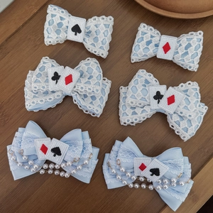 Flat lay of blue Lolita lace hair clips with poker embroidery and pearl chains