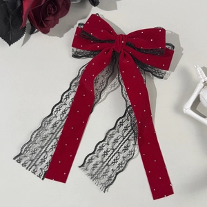Gros plan du nœud papillon en velours rouge avec dentelle noire et perles fines