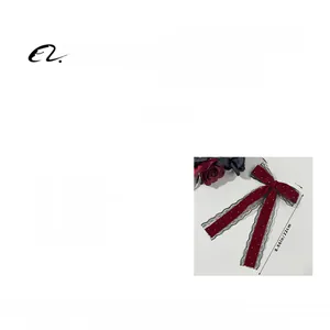 Detail showing red velvet bow hairpin with white polka dots and delicate lace trim