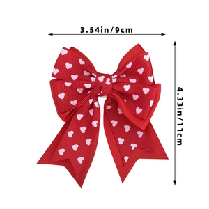 Detail view of red bow hair clip with white heart print showing 9cm by 11cm dimensions