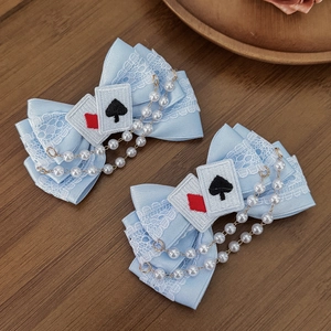 Detail of blue Lolita lace hair clips with playing card embroidery and pearl chains