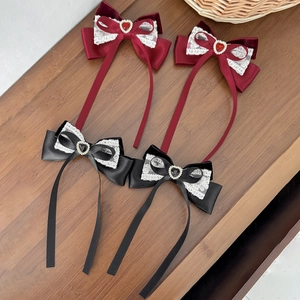 Close-up of Lolita style velvet lace hair clips with heart gems and long ribbons