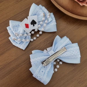 Detail of blue Lolita lace bow hair clips with poker embroidery and pearl chains