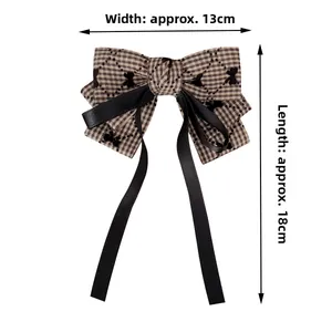 Detail of plaid bow hair clip with bear pattern and 13cm width by 18cm length ribbons