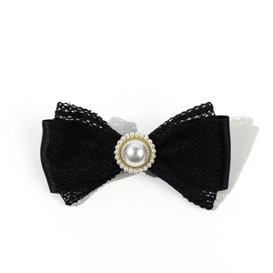 Detail of black lace bow brooch with pearl center and vintage gold finish metal