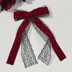 Close-up of vintage wine red velvet bow hair clip with lace layers and rhinestone details