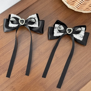 Detail of Gothic Lolita hair clips with black velvet bows, lace, and heart gemstones