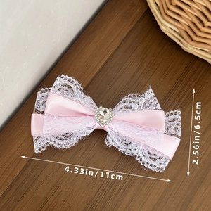 Roze strik haarclip met wit kant, hartvormige strass en de afmetingen in detail