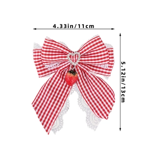 Detailed view of red plaid bow hair clip with lace trim and strawberry charm, 11x13cm size