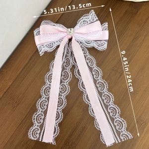 Detail van roze Lolita kant met strik en hartvormige strassteen inclusief de afmetingen