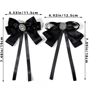 Detailed view of two black satin bow accessories with crystal centers and size labels