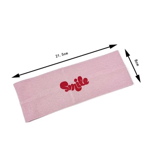 Pink rib-knit sports headband with red Smile print and 21.5cm by 8cm dimensions