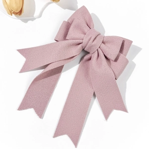Elegant dusty pink bow hair clip with long ribbons on white background with tulips