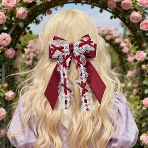 Détail d'un nœud papillon Lolita bordeaux avec dentelle sur cheveux blonds