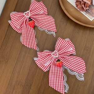 Red plaid bow hair clip with white lace trim, heart rhinestone, and strawberry charm