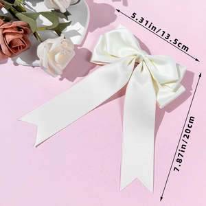 Detailed view of white satin bow hairclip with size dimensions 13.5cm by 20cm