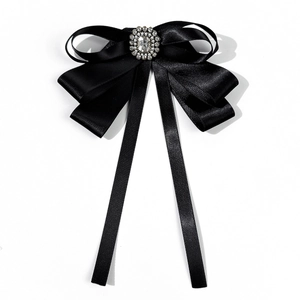Detail of elegant black satin bow tie brooch with sparkling central crystal rhinestones
