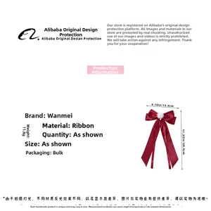 Detailed view of dark red bow hair clip with white fur ball and long ribbons