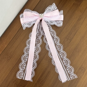 Roze Lolita haarstrik met wit kant en een fonkelende hartvormige strassteen in het midden
