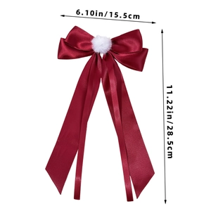 Detailed view of dark red satin bow with white fur ball and sizing measurements