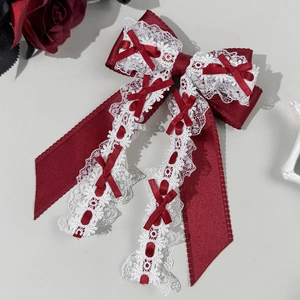 Détail d'une pince à cheveux nœud Lolita rouge foncé avec dentelle blanche et rubans