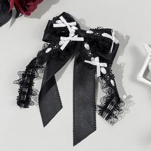 Détail de la pince à cheveux Lolita en dentelle noire avec petits nœuds blancs
