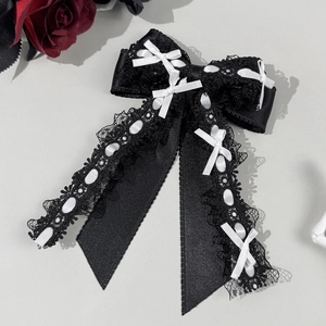 Détail macro de la barrette Lolita en dentelle noire avec rubans blancs et volants