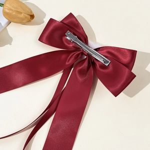 Elegant wine red satin bow hair clip with long ribbons and white pompom detail