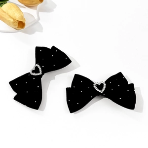 Detail of black velvet bow hair clips with sparkling heart rhinestones and silver studs
