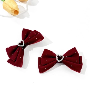 Detail of red velvet bow hair clips with rhinestone hearts and silver dots decor