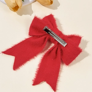 Elegant red wool bow hair clip with silver metal alligator clip on warm beige background