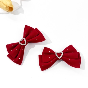 Pair of red velvet bow hair clips with heart rhinestones and silver sparkle accents