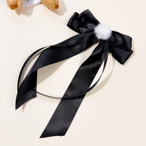 Elegant black satin ribbon hair clip with white fur pom-pom detail on white background