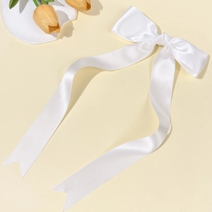 Fermaglio per capelli fiocco in raso bianco con nastri lunghi su sfondo giallo