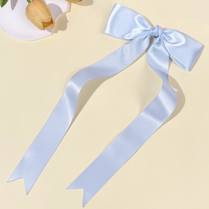 Dettaglio del fermaglio a fiocco in raso azzurro con eleganti nastri lunghi
