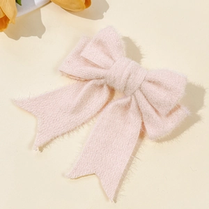 Detailed texture of pink mohair bow hair clip showing soft fabric and elegant craftsmanship