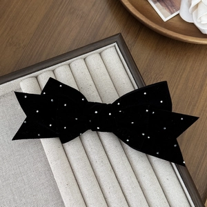 Detail view of a French vintage black velvet bow hair clip with sparkling rhinestones