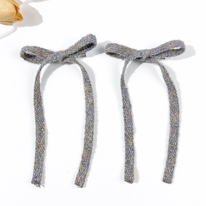 Elegant pair of blue-grey tweed bow hair clips with long ribbons on white background